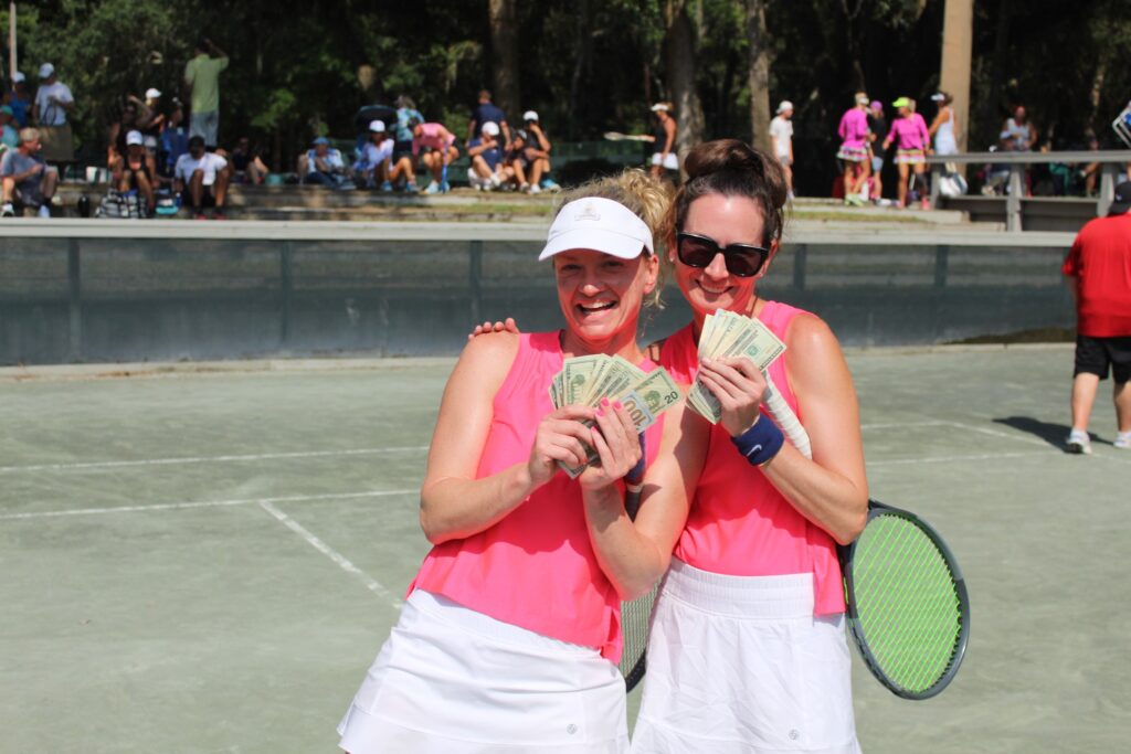 Womens doubles winning money at tennis party.
